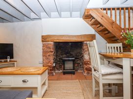 A living room with a fireplace and television at 1 Myrtle Cottages in Stokeinteignhead