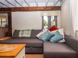 A living room with a sofa and cushions at 1 Myrtle Cottages Stokeinteignhead