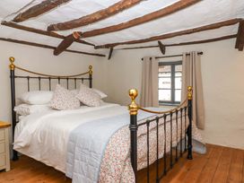 A bedroom with a bed and pillows at 1 Myrtle Cottages in Stokeinteignhead