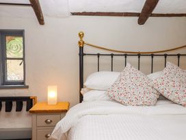A bedroom with a bed and lamp at 1 Myrtle Cottages Stokeinteignhead