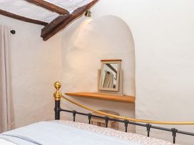 A bedroom with a bed and a mirror on the wall at 1 Myrtle Cottages Stokeinteignhead