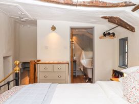 A bedroom with a bed and a bathroom view at 1 Myrtle Cottages Stokeinteignhead