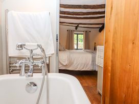 A bathroom featuring a bathtub and a view of a bedroom at 1 Myrtle Cottages Stokeinteignhead