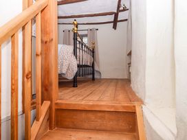 A staircase leading to a bedroom with a bed and curtains at 1 Myrtle Cottages Stokeinteignhead