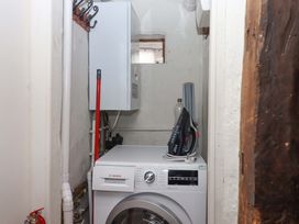 A laundry room with a washing machine and a boiler at 1 Myrtle Cottages in Stokeinteignhead
