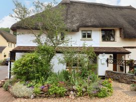 A house with a thatch roof and garden at 1 Myrtle Cottages in Stokeinteignhead