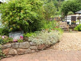 A garden with flowers and a bench at 1 Myrtle Cottages Stokeinteignhead