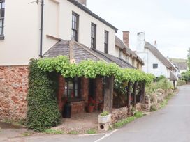 An outdoor area with vines and flowers at 1 Myrtle Cottages in Stokeinteignhead