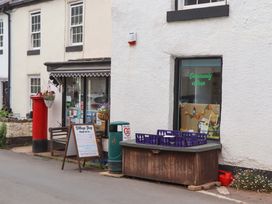 A village shop with a red post box and a display table at 1 Myrtle Cottages in Stokeinteignhead