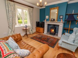 A living room with a fireplace and sofa at 9 Longhirst Village in Morpeth