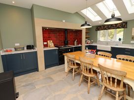 A kitchen featuring a dining table and oven at 9 Longhirst Village in Morpeth
