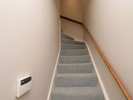 A staircase with carpet and a handrail at 9 Longhirst Village Morpeth