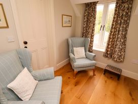 A sitting room with armchairs and a small footstool at 9 Longhirst Village Morpeth