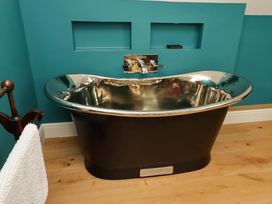 A bathroom with a bathtub and faucet at 9 Longhirst Village in Morpeth