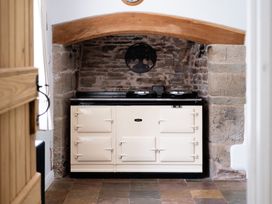 A kitchen with an oven and brick wall at Henhouse Farm in Bodenham