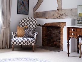 A living room with an armchair and fireplace at Henhouse Farm in Bodenham