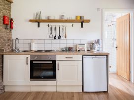A kitchen with a sink, stove and refrigerator at Henhouse Farm in Bodenham