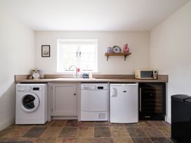A laundry room with appliances and a window at Henhouse Farm in Bodenham
