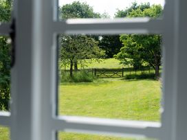 An outdoor view showing trees and a gate from a window at Henhouse Farm Bodenham