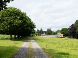 A path leading to a house with trees and grass at Henhouse Farm in Bodenham