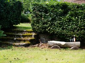 A garden with a wooden bench and drinks at Henhouse Farm in Bodenham