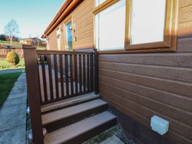 Outdoor wooden stairs with railing leading to a wooden deck attached to a brown cabin at The Sanctuary Badgers Retreat Holiday Park near Catterick Garrison North Yorkshire