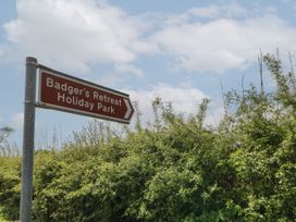 A road sign pointing to Badgers Retreat Holiday Park with trees and sky in the background at The Sanctuary in Badgers Retreat Holiday Park near Catterick Garrison North Yorkshire