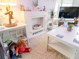 A living room with dolls and a television at The Sanctuary near Badgers Retreat Holiday Park near Catterick Garrison, North Yorkshire