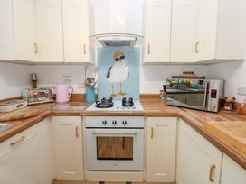 A kitchen with stove and microwave at The Sanctuary Badgers Retreat Holiday Park near Catterick Garrison, North Yorkshire