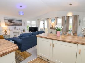 A living room with a sofa, television and dining table at The Sanctuary near Badgers Retreat Holiday Park near Catterick Garrison, North Yorkshire