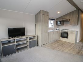 A kitchen with cabinets and appliances at Lido Gold 120 in Prestatyn