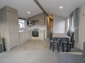 A kitchen with appliances and dining area at Lido Gold 120 Prestatyn