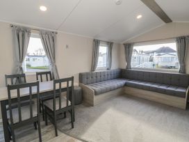 A living room with a table and chairs at Lido Gold 120 in Prestatyn