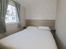 A bedroom with a bed and window at Lido Gold 120 in Prestatyn