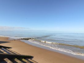 A beach with ocean waves and a clear sky at Lido Gold 120 Prestatyn