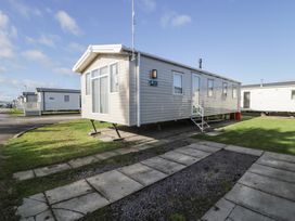A mobile home with steps and a lawn at Lido Gold 205 Prestatyn