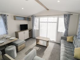 A living room with a television and seating area at Lido Gold 205 Prestatyn