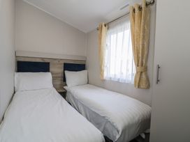 A bedroom with two single beds and a window at Lido Gold 205 Prestatyn