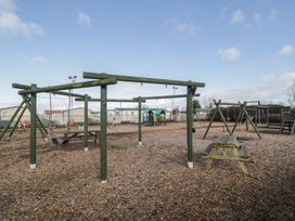 A playground with swings and a play structure at Lido Gold 205 Prestatyn