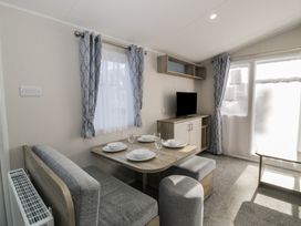 A dining area with a table and chairs at Lido Gold 273 in Prestatyn