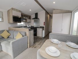 A kitchen with a sofa and dining table at Lido Gold 273 Prestatyn