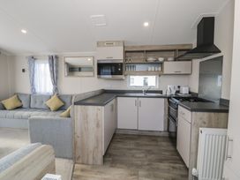 A kitchen area with a sofa and appliances at Lido Gold 273 Prestatyn