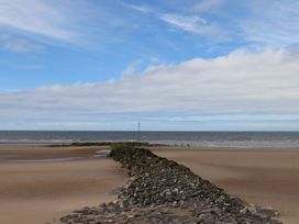 A beach with a rock formation leading to the sea at Lido Gold 273 Prestatyn
