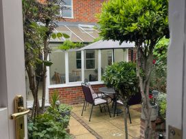 A garden with a table and chairs under an umbrella at Bay Tree Cottage, Peasenhall