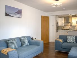 A living room with two sofas and a kitchen in the background at Maceley in Kingsbridge