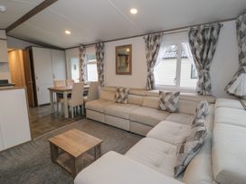A living room with a sofa and a dining table at Woodlands Gold (WO40) Ruthin