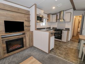 A kitchen with appliances and a television at Woodlands Gold (WO40) in Ruthin