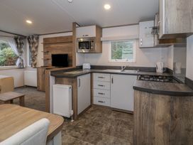 A kitchen with cabinets and appliances at Woodlands Gold (WO40) in Ruthin