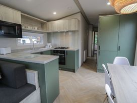 A kitchen with appliances and seating at Woodlands Gold (WO06) in Ruthin