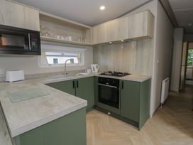 A kitchen with a gas stove and sink at Woodlands Gold (WO06) in Ruthin